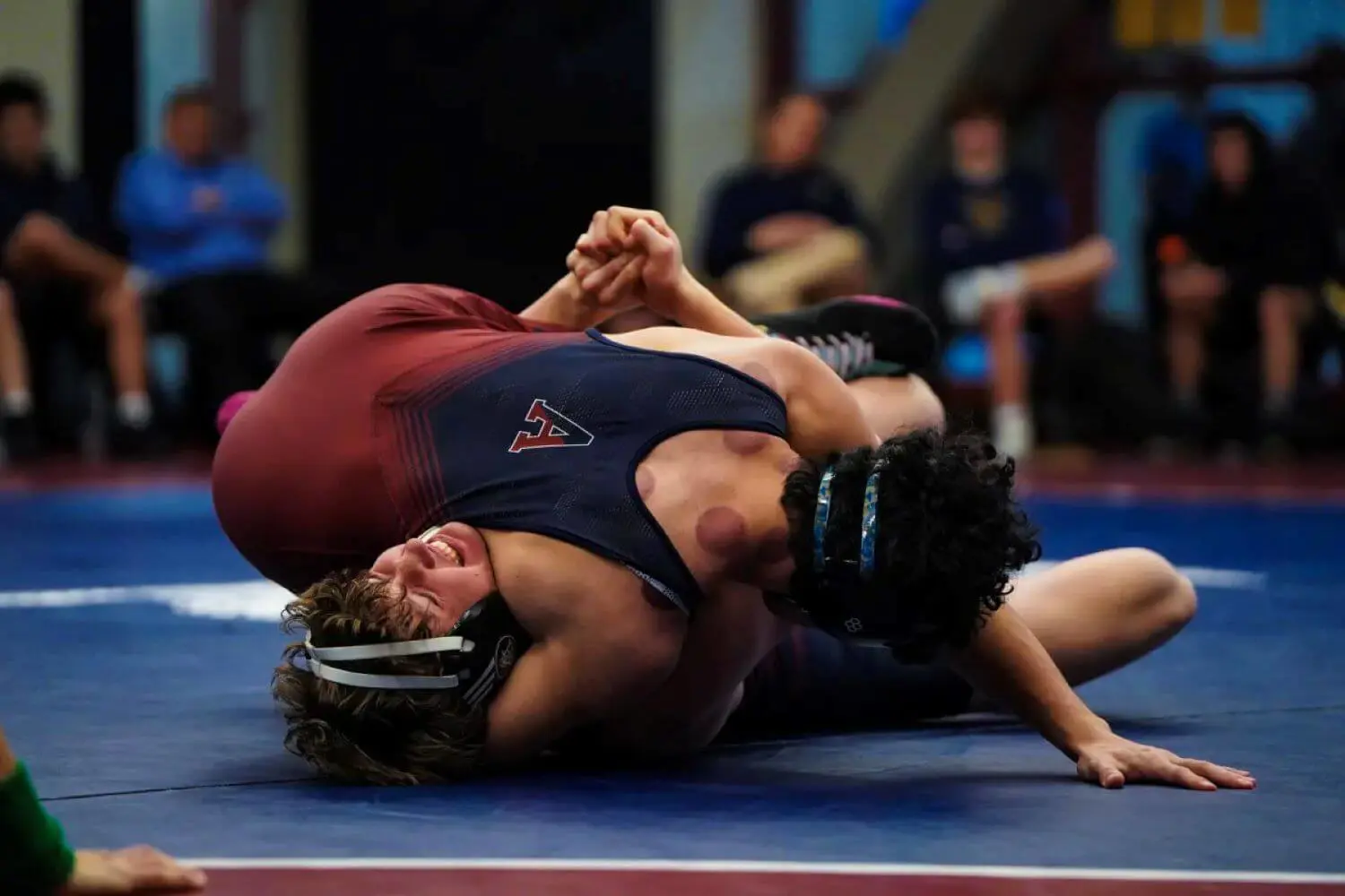 Avon Old Farms student wrestling an opponent.