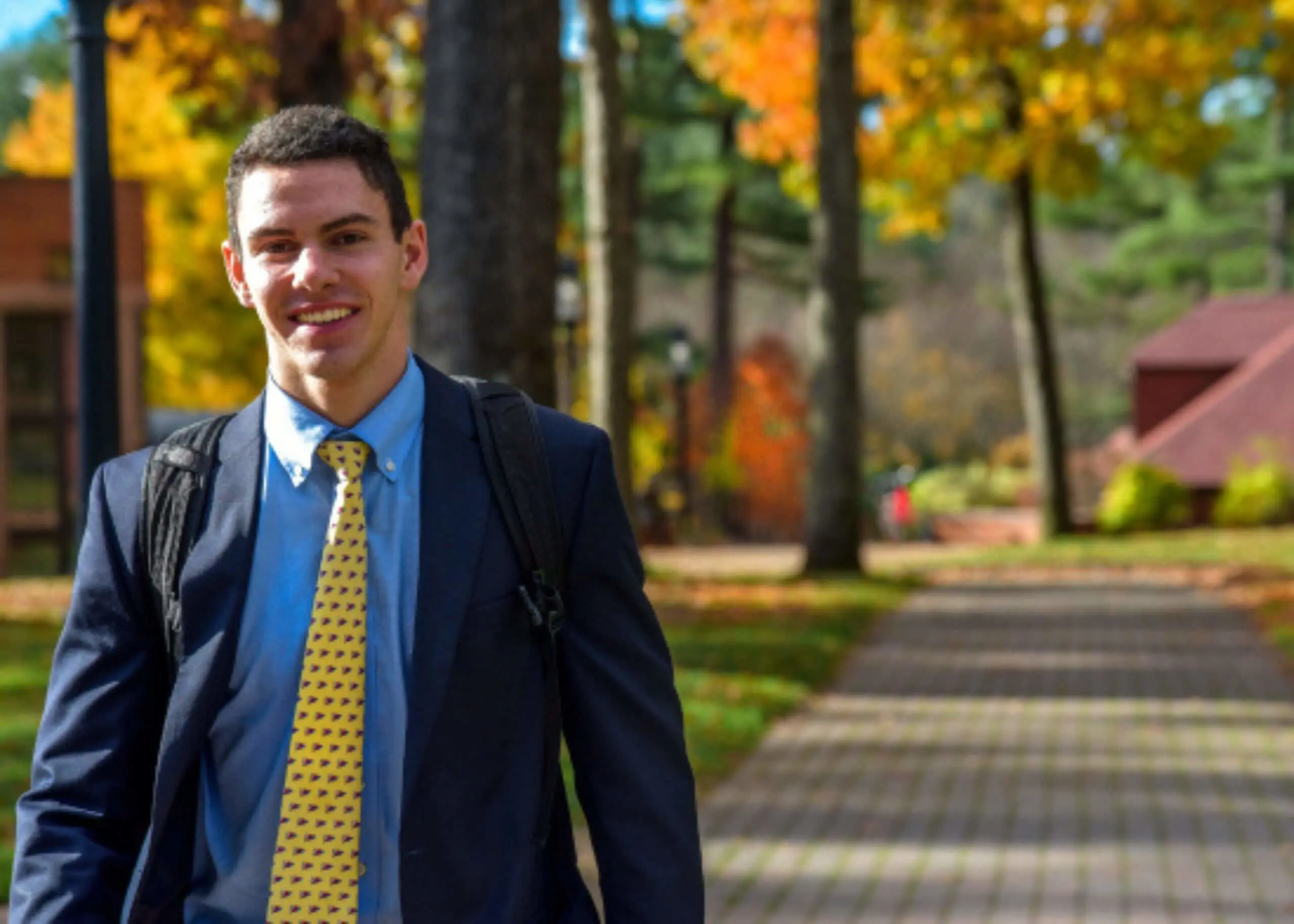 Avon Old Farms student walking through campus in Fall