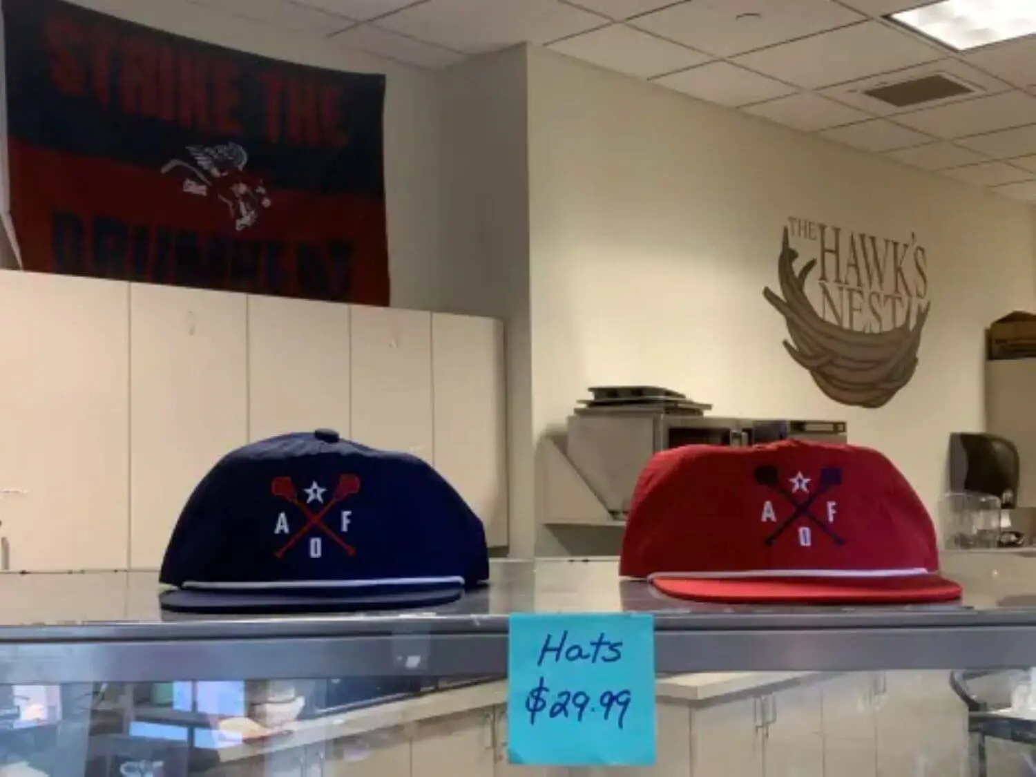 Blue and red hats manufactured by Anthony Crimmins ’01.
