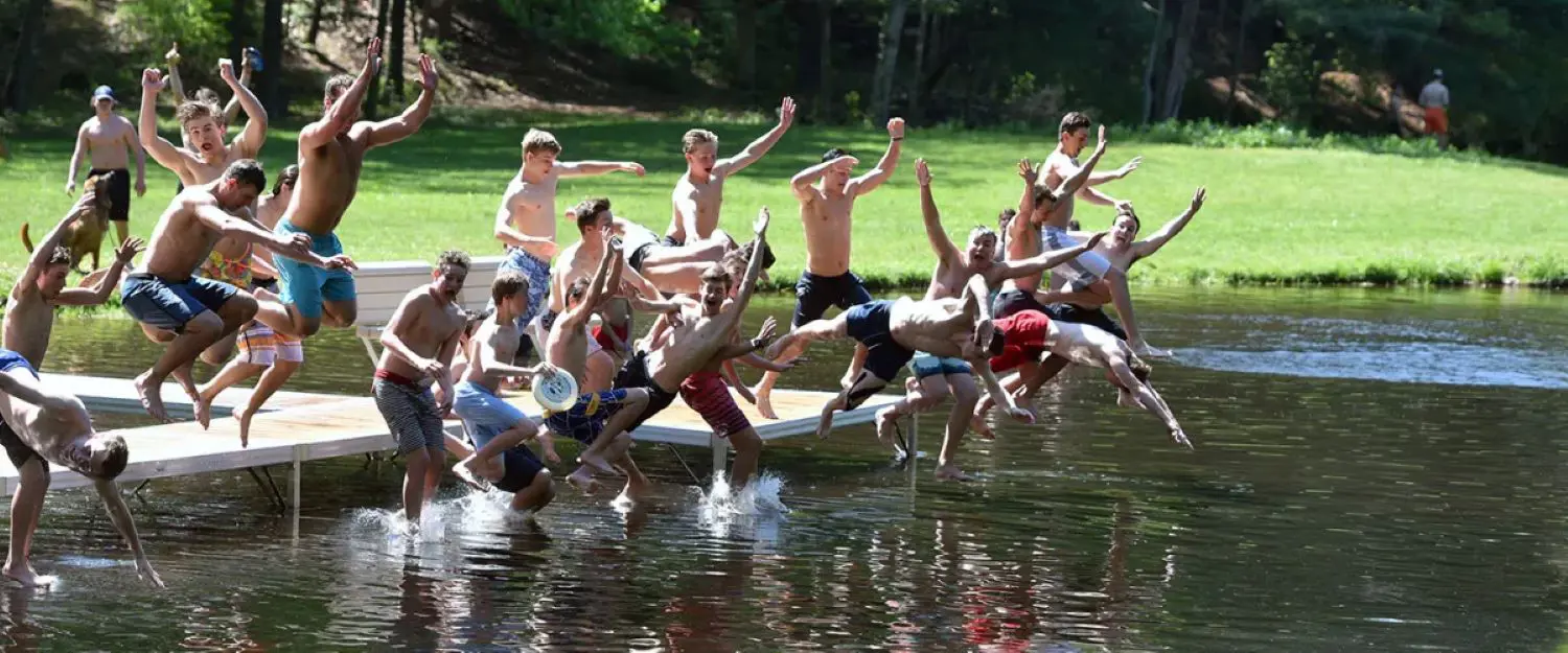 Avon Old Farms students jumping into Beaver Pond.