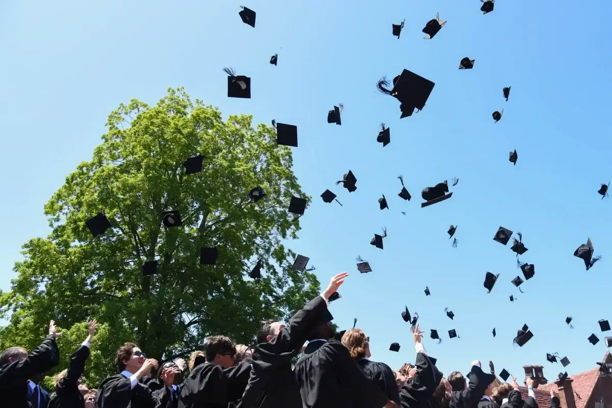 Avon Old Farms students throwing graduation caps into the air