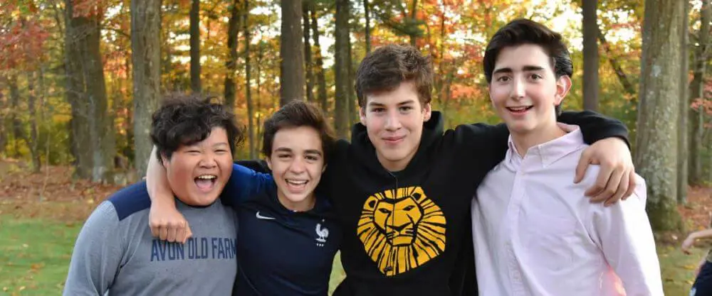 Avon Old Farms students smiling and laughing together on campus.