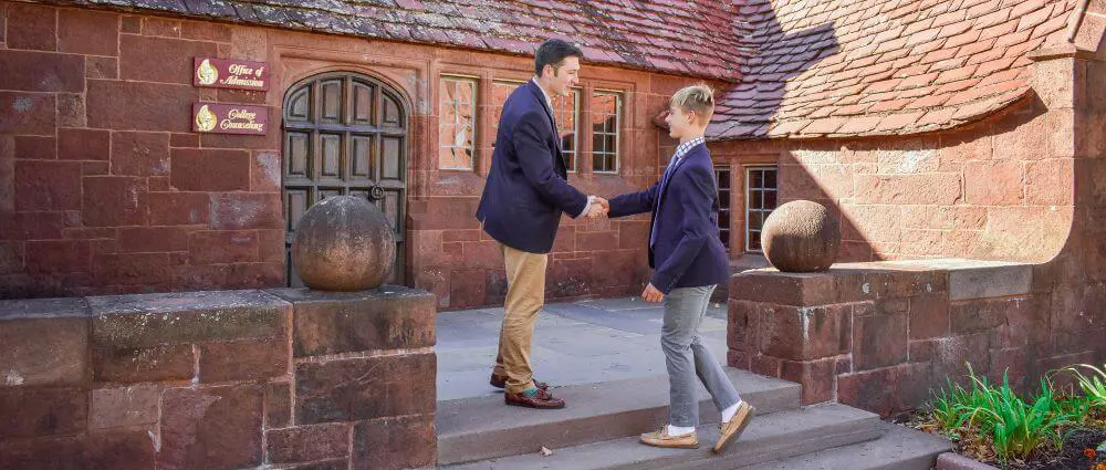 Avon Old Farms teacher shaking hands with a prospective student.