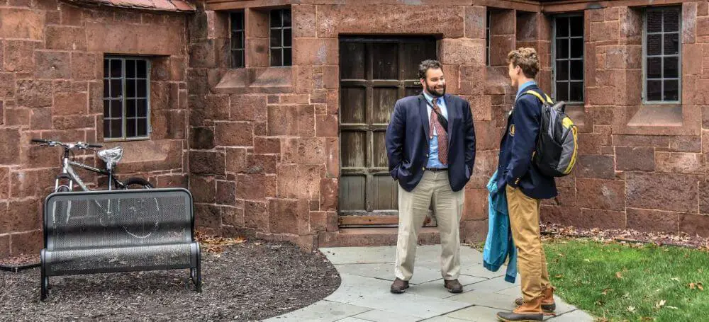 Avon Old Farms student and teacher chatting in the quadrangle.