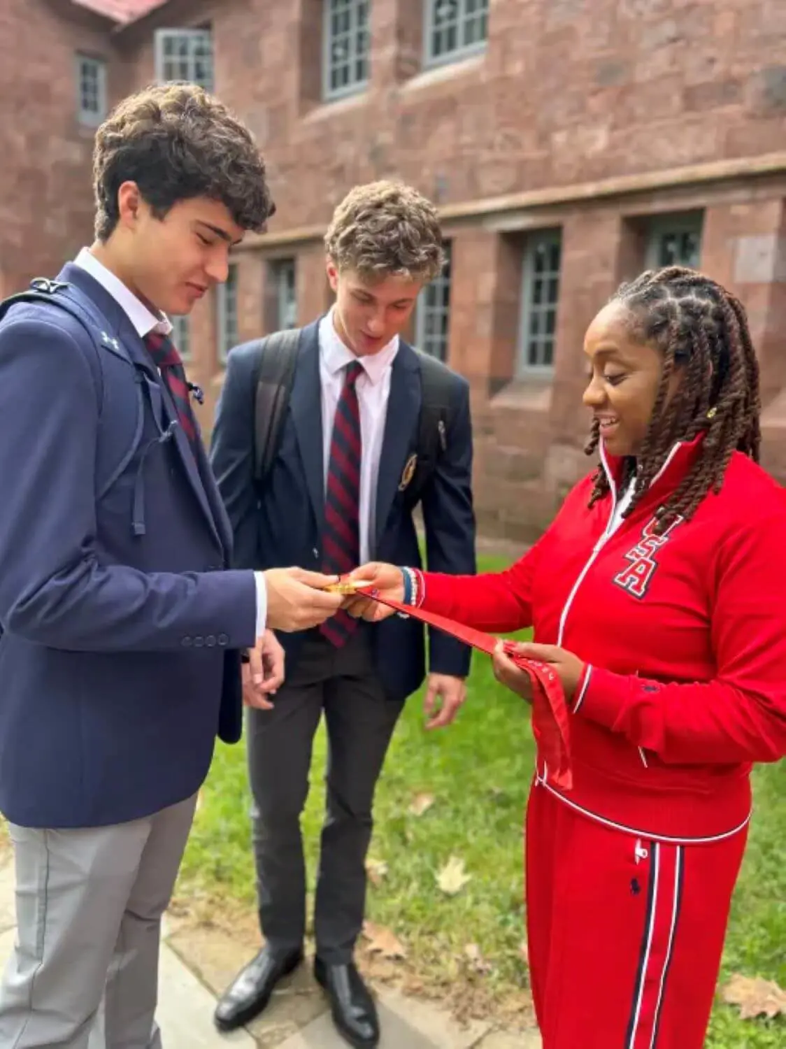 Paralympic Gold Medalist Sydney Satchell showing medal to Avon Old Farms students