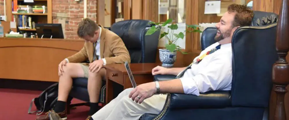 Avon Old Farms student & teacher laughing.