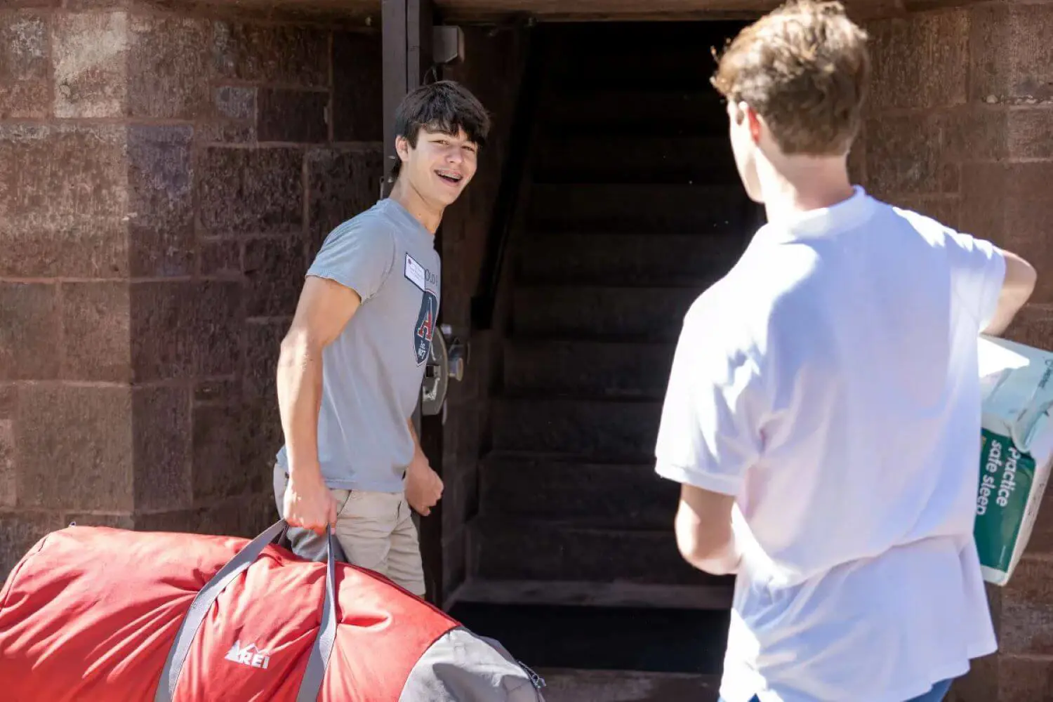 Avon Old Farms student carrying luggage into the boarding house.